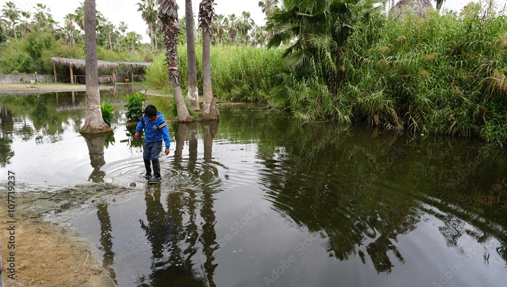 Child playing in flooded water in Mexico