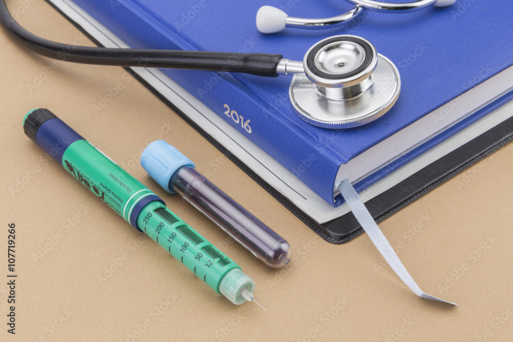 stethoscope and a book on brown background, pencil of insulin an stethoscope and a book on brown background, pencil of insulin an