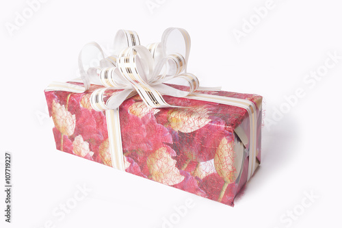 Single red gift box with silver ribbon on white background.