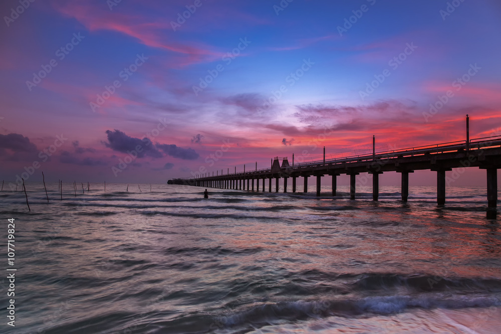 Silhouette morning sunrise over sea pier in Thailand