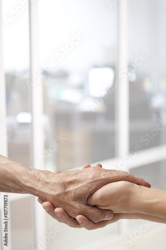 Female hands touching old male hand