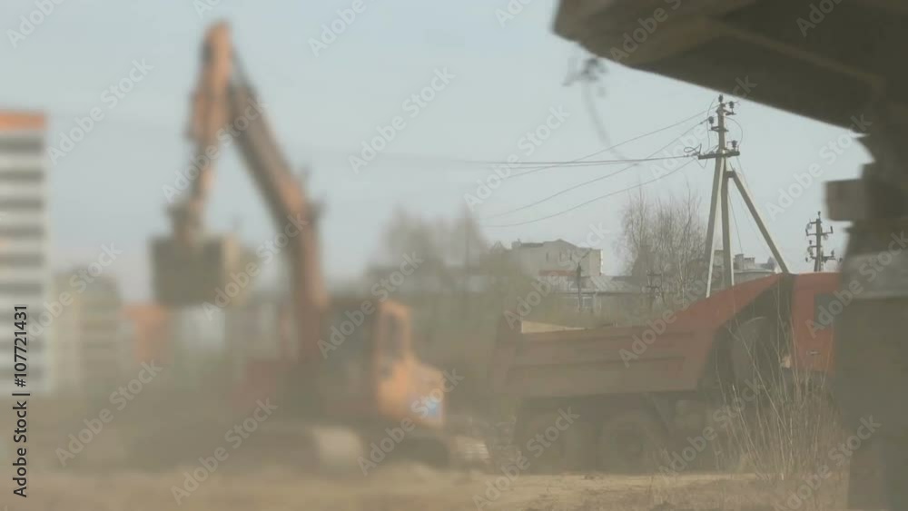 Excavator loads soil into a truck at construction Excavator loads soil into a truck at construction