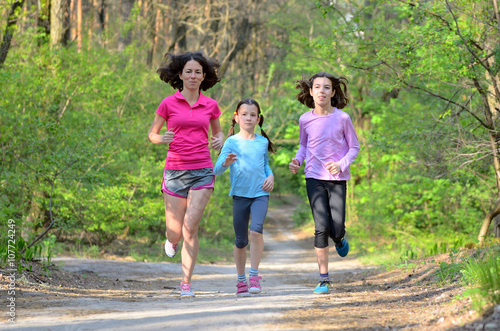 Family sport  happy active mother and kids jogging outdoors  running in forest  