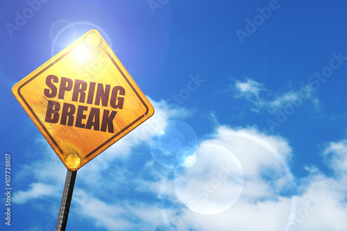 Fotografi Yellow road sign with a blue sky and white clouds: spring break