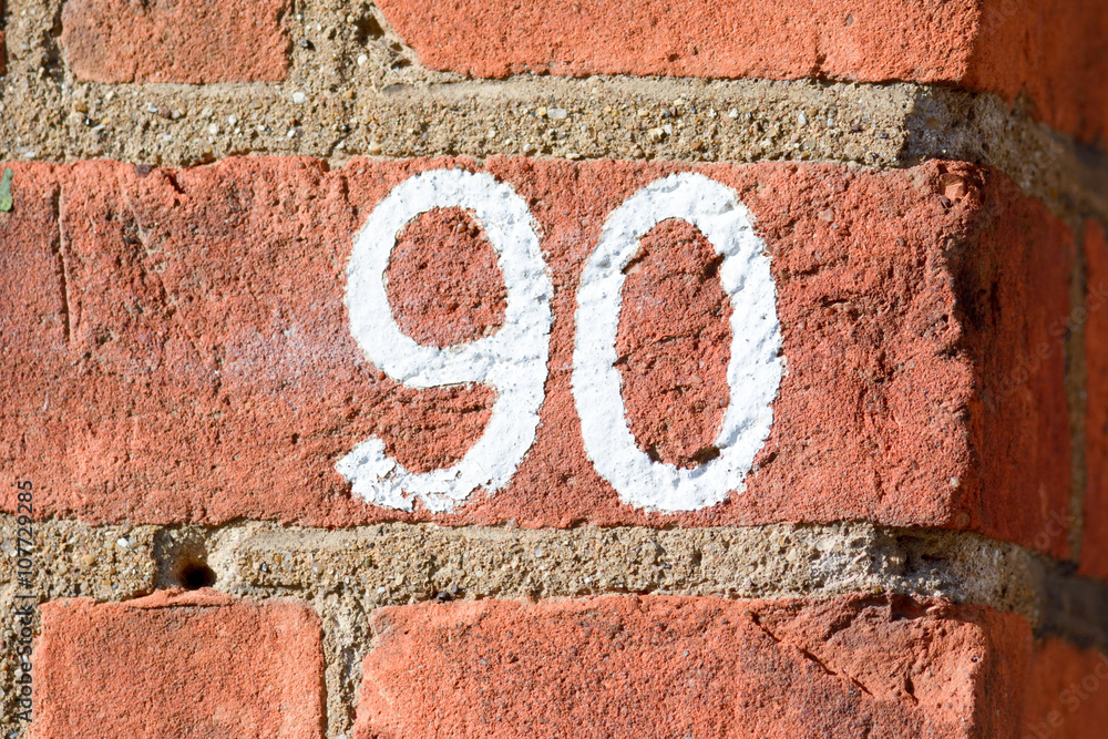 House number 90 sign painted on wall House number 90 sign painted on wall