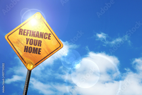 Yellow road sign with a blue sky and white clouds: refinance you photo