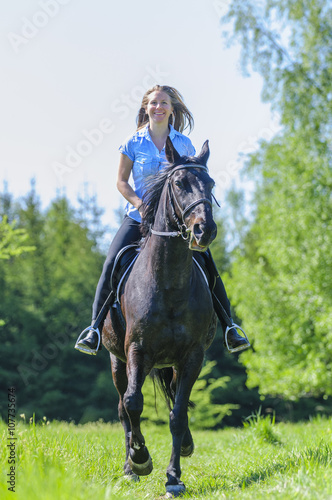 Frau hat Spass beim Ausritt mit ihrem Pferd