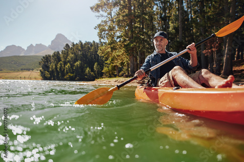 Принти на полотні Mature man with enjoying kayaking in a lake