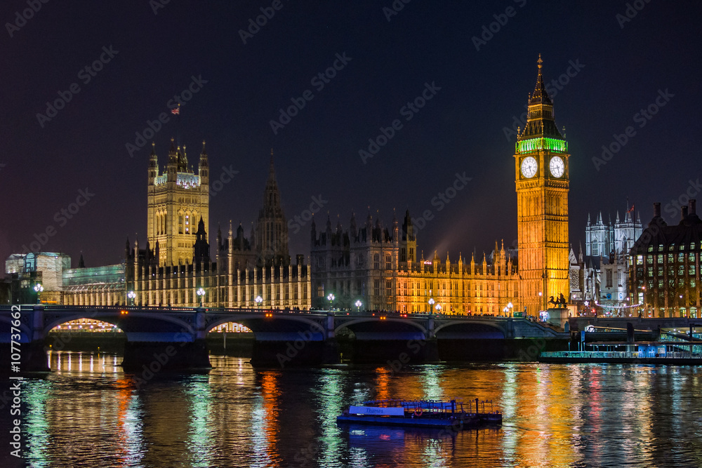 London Big Ben Westminster parliament Thames with boat and bridge in night