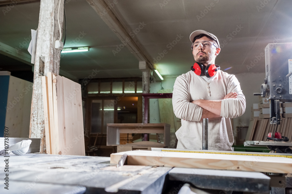 Carpenter working with Industrial tool in wood factory wearing safety glasses and hearing protection. Carpenter working with Industrial tool in wood factory wearing safety glasses and hearing protection.