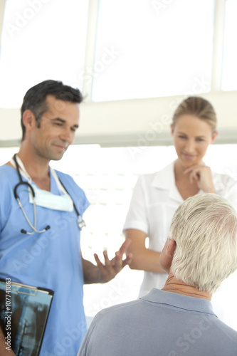 Doctor and nurse talking to senior patient at the hospital