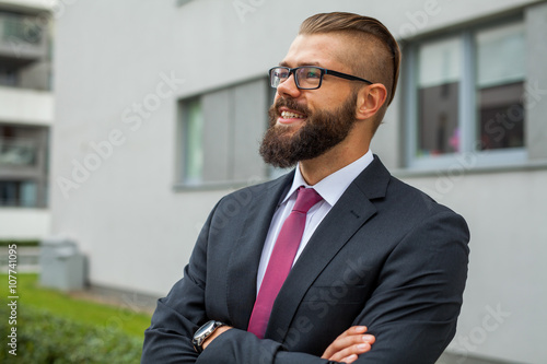 Portrait of a young happy businessman outside the office buildin
