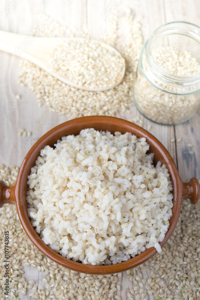 Cooked steamed rice in a blue bowl over wooden background Cooked steamed rice in a blue bowl over wooden background