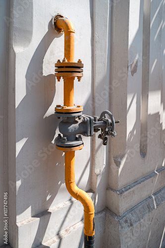 Natural gas valve with steel pipe in bright sunny summer day photo