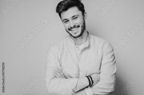 black and white portrait of handsome smiling man isolated on gray studio background posing to the camera