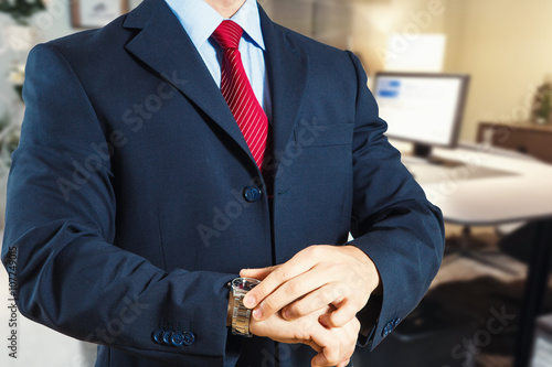 uomo in ufficio che controlla con l'orologio l'orario