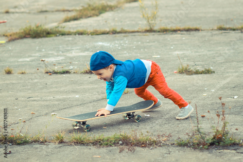 little boy having fun with skateboard outdoors.