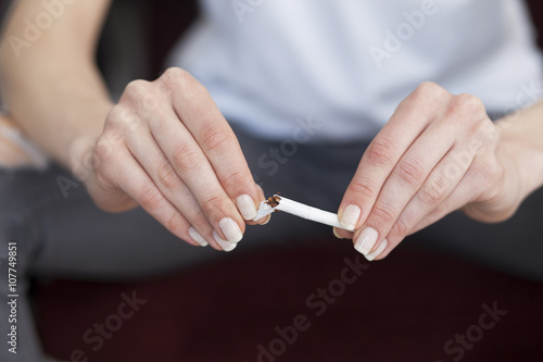 Close up of woman hands with broken cigarette. Stop smoking concept