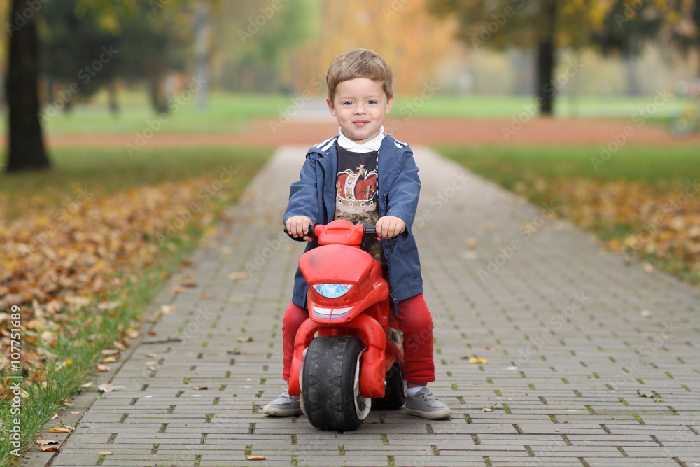cute little biker on road with motorcycle. Young boy on toy motorcycle cute little biker on road with motorcycle. Young boy on toy motorcycle