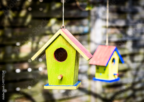 Two old weathered DIY birdhouses hanging from the tree