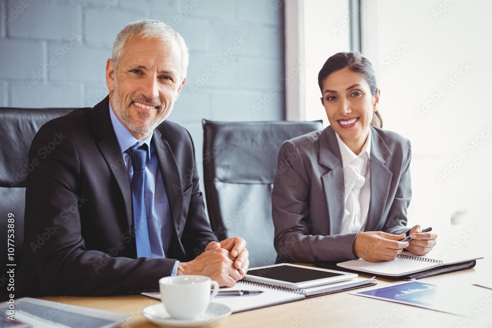 Businessman and businesswoman sitting in conference room Businessman and businesswoman sitting in conference room