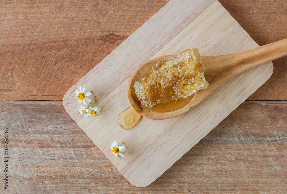 Fresh honey with honeycomb on a wooden chopping board