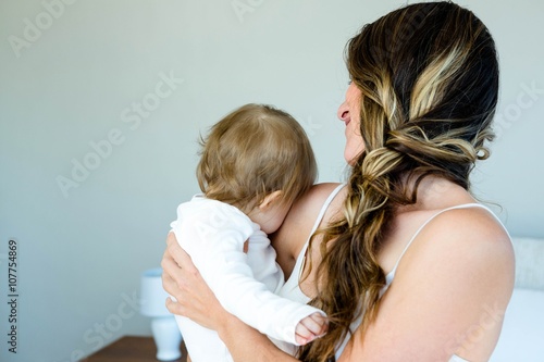 smiling brunette woman holding a baby