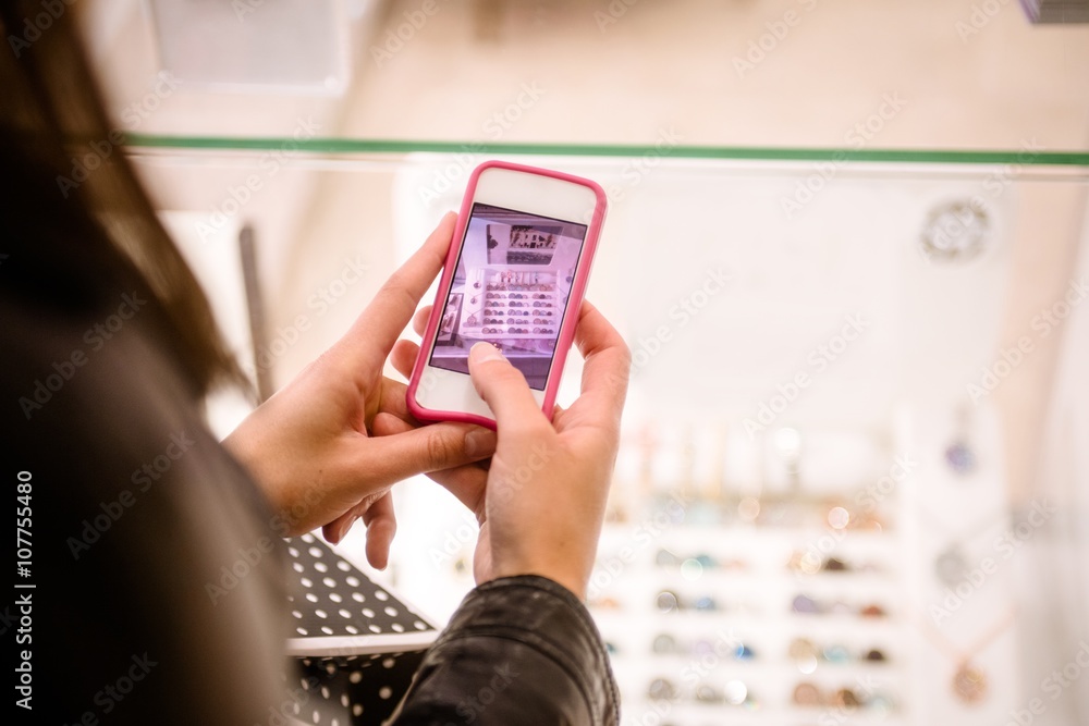 Close-up of womans hand clicking a photo of shop display Close-up of womans hand clicking a photo of shop display