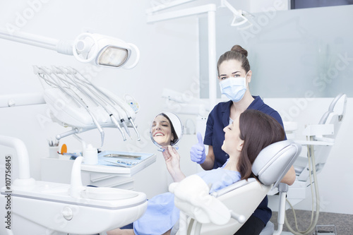 Beautiful woman patient having dental treatment at dentist's office. Woman visiting her dentist photo