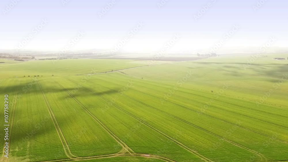Aerial shot of farm land crops following tractor Aerial shot of farm land crops following tractor