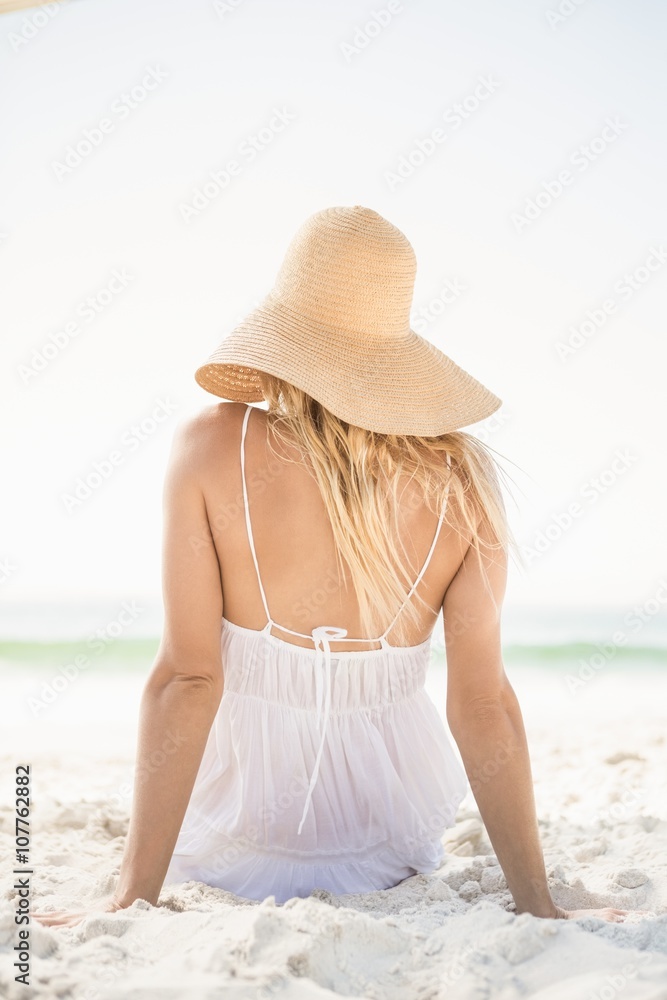 Blonde woman sitting on sand