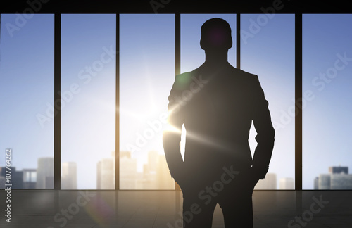 silhouette of business man over office background