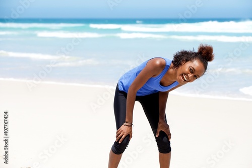 Healthy young african woman laughing at the beach