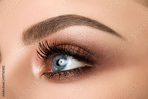 Close-up of woman eye with beautiful brown smokey eyes makeup photo