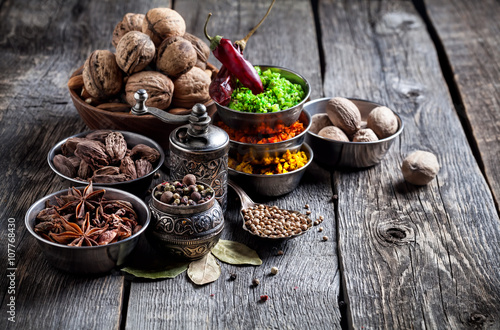 Photo Spices and nuts at wooden table