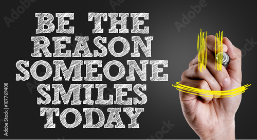 Hand writing the text: Be The Reason Someone Smiles Today photo