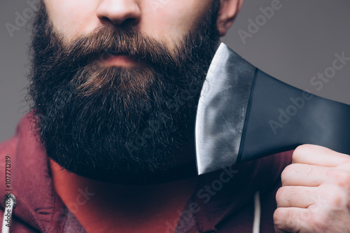 Canvas Print Close up of beard Confident young bearded man carrying a big axe on shoulder and
