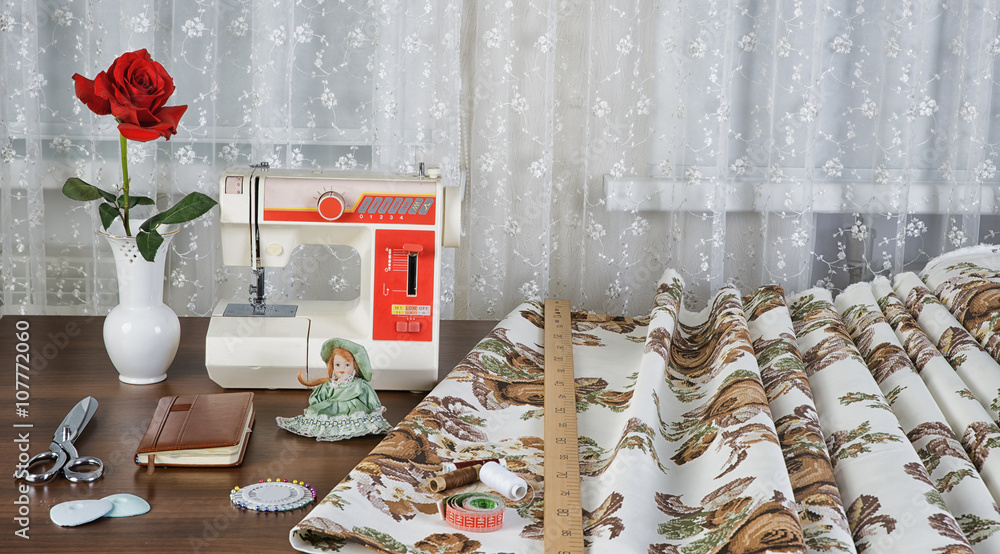 workplace оf seamstress with the sewing machine and retro fabri