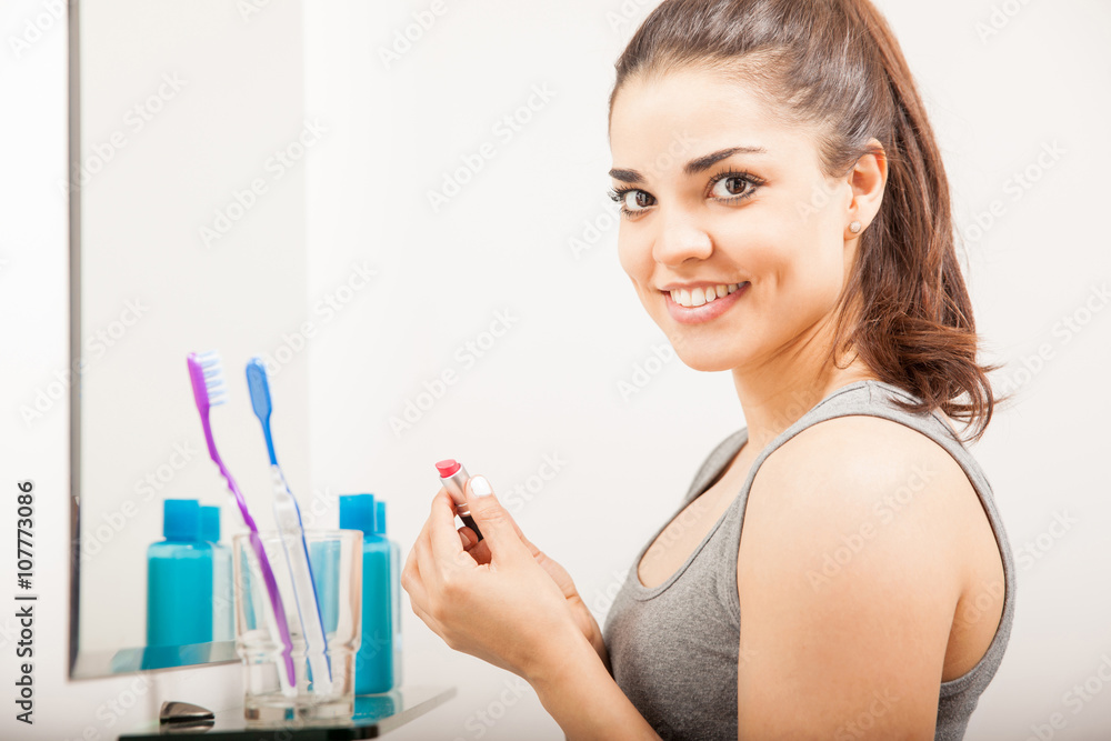 Beautiful girl putting some lipstick on Beautiful girl putting some lipstick on