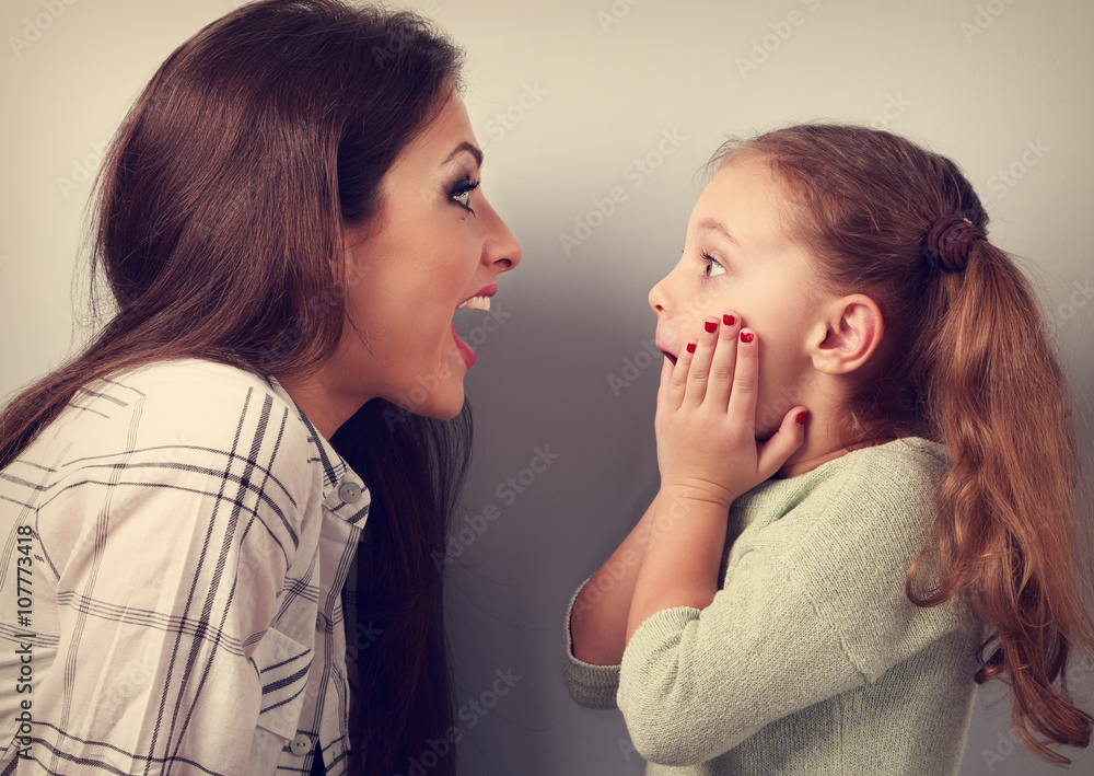 Excited mother and surprising kid girl looking on each other wit Excited mother and surprising kid girl looking on each other wit