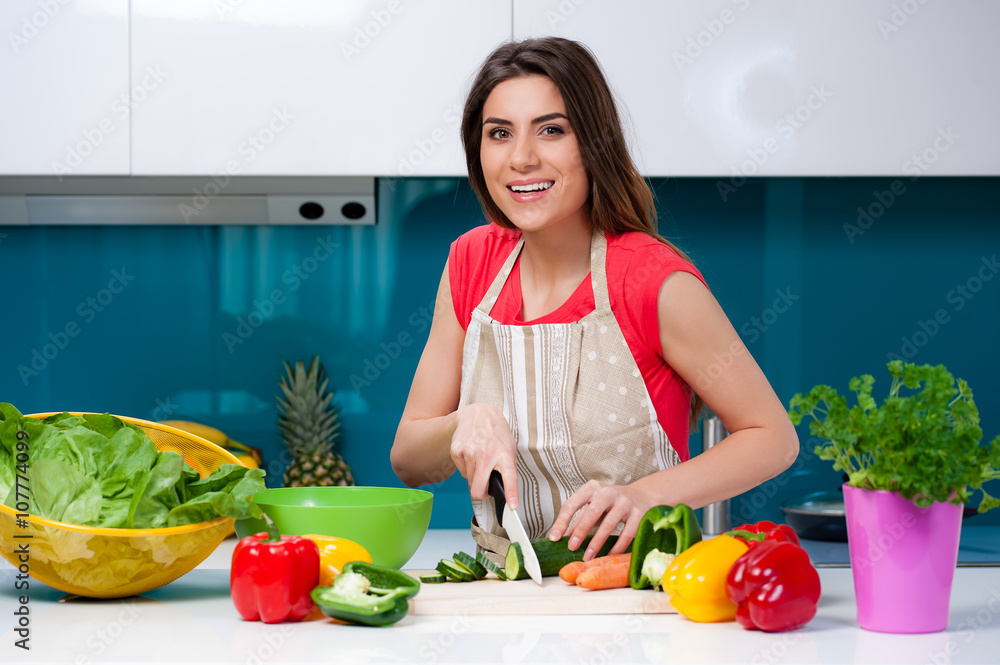 Young woman cooking in the kitchen healthy food, vegetable Salad. Holding a knife and cutting vegetables on a cutting board. Healthy lifestyle cooking at home. Young woman cooking in the kitchen healthy food, vegetable Salad. Holding a knife and cutting vegetables on a cutting board. Healthy lifestyle cooking at home.