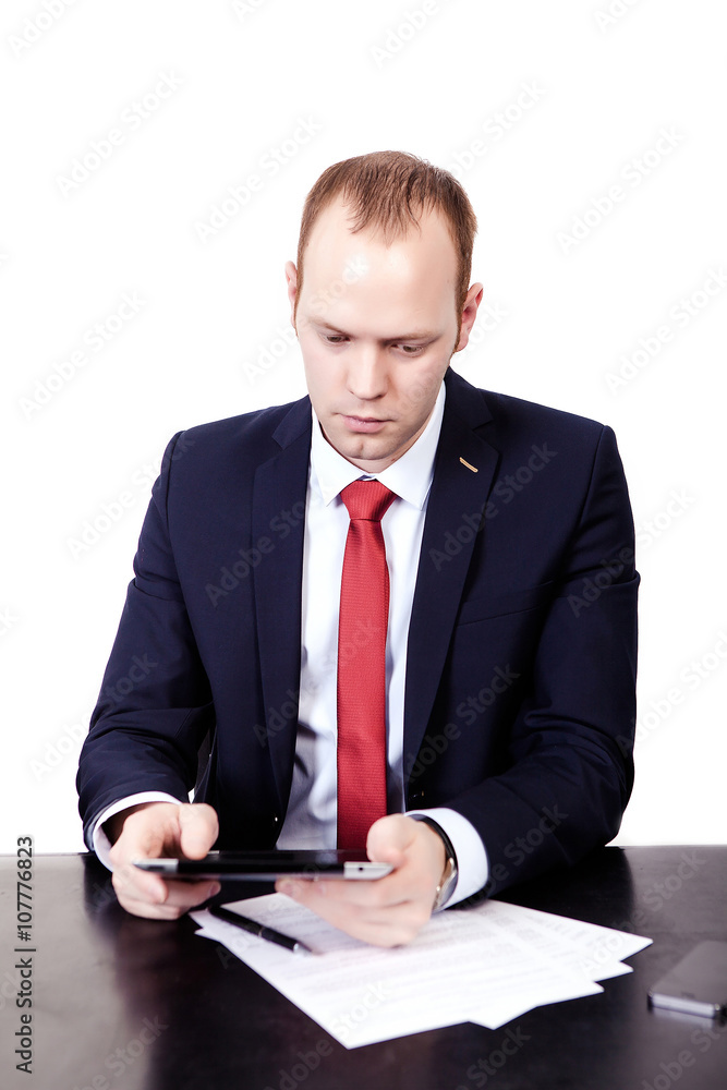 Serious American Businessman in red tie at the table working on Serious American Businessman in red tie at the table working on