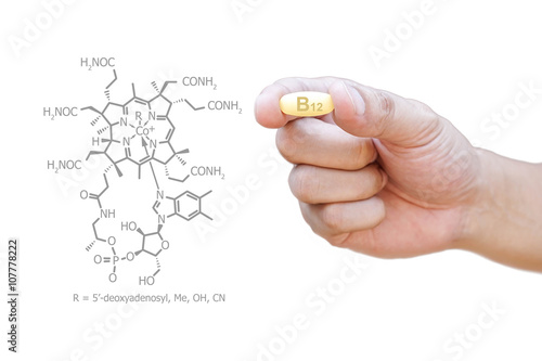 Hand holding vitamin B12 pill with clipping path