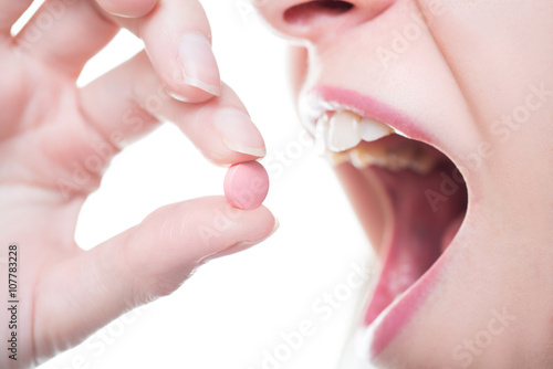 Girl puts a pill to his mouth