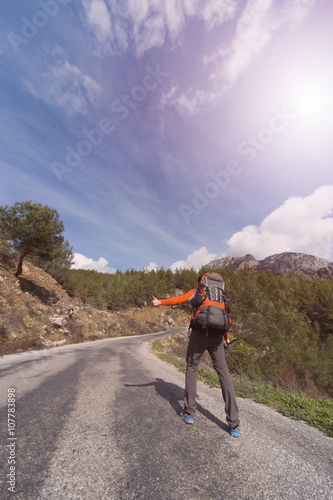 A man with a backpack on the road traveling. 