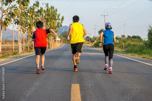 Group of Young man and woman running on a rural road during suns