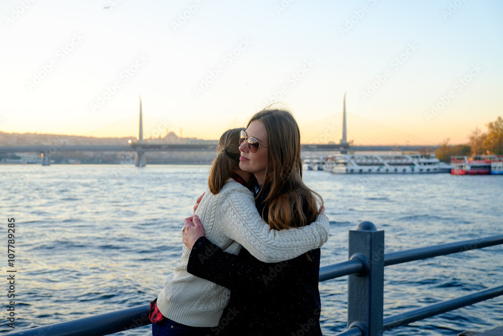 Hugging young mother with her daughter on the background Bosphorus in Istanbul