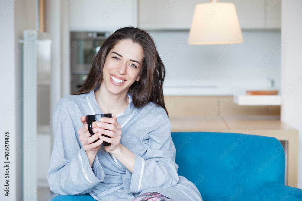 Woman sitting in sofa in the living room. Morning scene Woman sitting in sofa in the living room. Morning scene