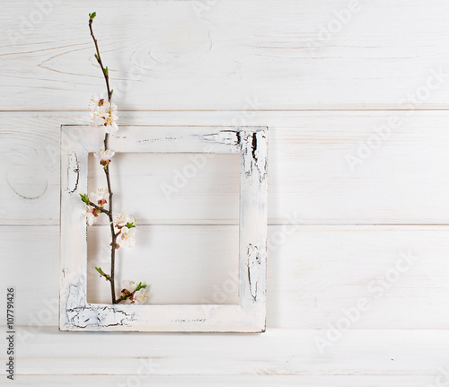 Decorated frame and apricot flowers in interior on wooden boards in shabby chic style