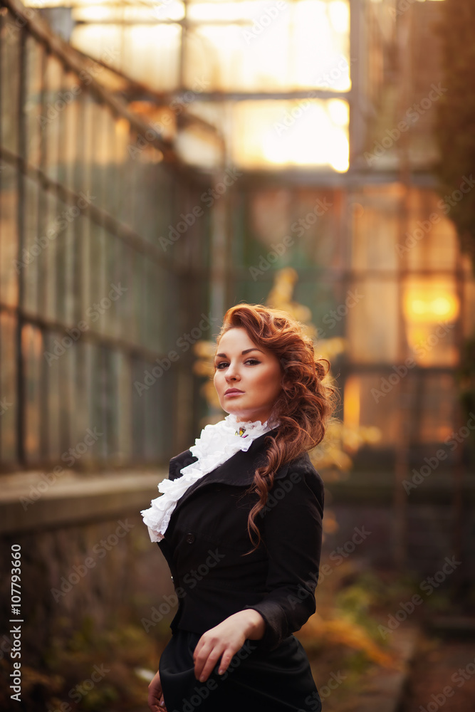 Fototapeta premium Sweet red-haired girl in a black vintage clothing
